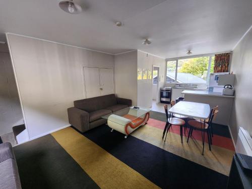 a living room with a couch and a table at Pinewood Lodge in Queenstown