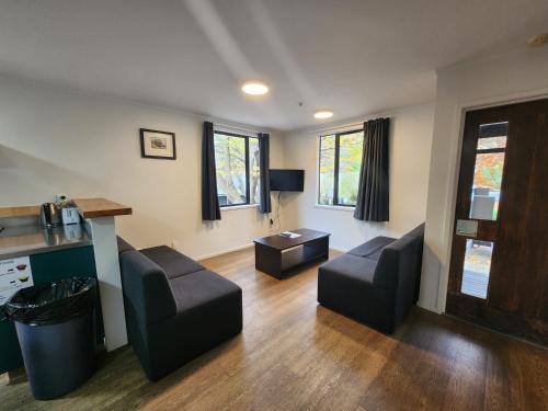 a living room with two chairs and a table at Pinewood Lodge in Queenstown