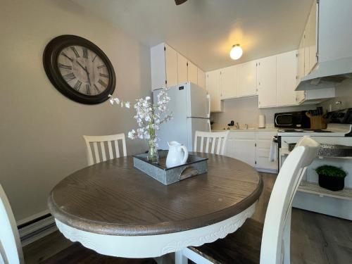 a kitchen with a table and a clock on the wall at Campus West Nest - King Bed, Walk to CSU in Fort Collins