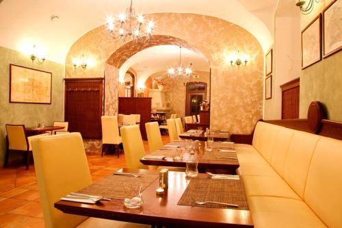 a restaurant with wooden tables and chairs and a dining room at Hotel Zámek Berchtold in Kunice - Vidovice