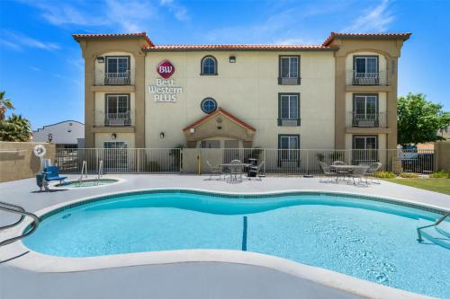 a hotel with a swimming pool in front of a building at Best Western Plus John Jay Inn & Suites in Palmdale