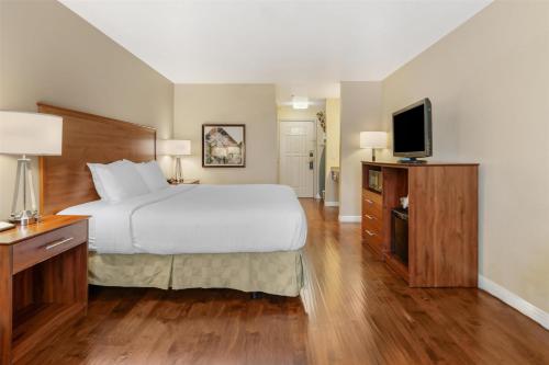 a hotel room with a bed and a flat screen tv at Best Western Plus John Jay Inn & Suites in Palmdale