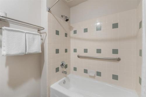 a white bathroom with a tub and a sink at Best Western Plus John Jay Inn & Suites in Palmdale