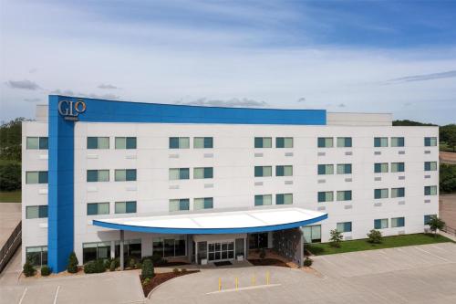a large white building with a blue roof at GLō Best Western Tulsa-Catoosa East Route 66 in Catoosa