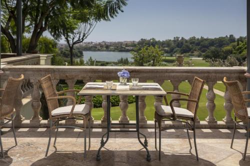 a table and chairs on a balcony with a view at Anantara Villa Padierna Palace Benahavís Marbella Resort - A Leading Hotel of the World in Estepona