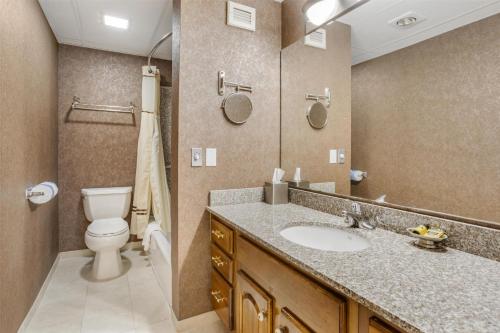a bathroom with a sink and a toilet and a mirror at Best Western PLUS Morristown Inn-Florham Park in Morristown