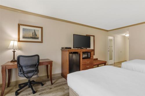 a hotel room with a desk and a bed and a chair at Best Western PLUS Morristown Inn-Florham Park in Morristown