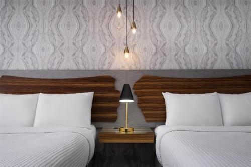 a bedroom with two beds and a table with a lamp at Aiden by Best Western St George in St. George