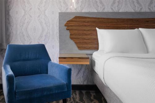 a bedroom with a bed and a blue chair at Aiden by Best Western St George in St. George