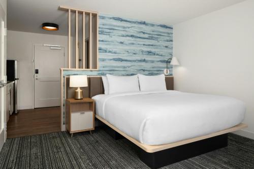 a bedroom with a large bed and a painting of a ocean at TownePlace Suites by Marriott Allentown West in Allentown