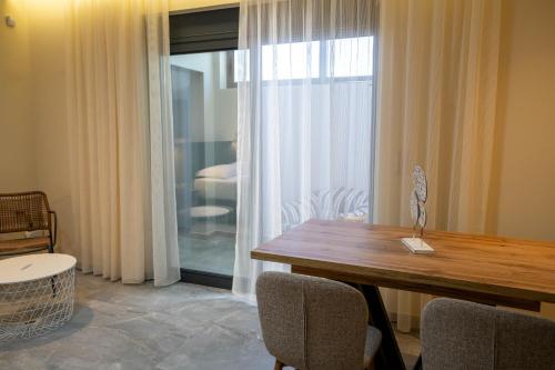 a dining room with a table and chairs and a window at Kalon Gaia NOSTOS in Karistos