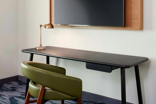 a desk with a green chair and a lamp at Fairfield by Marriott Inn & Suites Alpharetta Avalon Area in Alpharetta