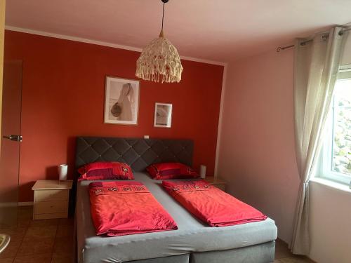 a bedroom with red walls and a bed with red pillows at Ferienwohnung am Nurburgring in Welcherath