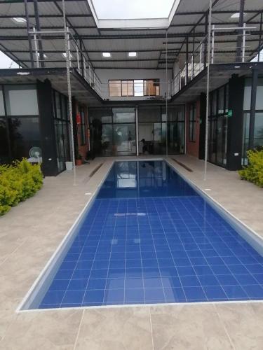 a large swimming pool in a building with blue tiles at VILLA CARO in Palestina