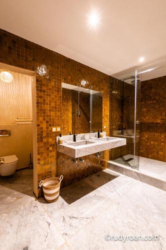 a bathroom with a double sink and a shower at Les terrasses du Lac Marrakech in Lalla Takerkoust