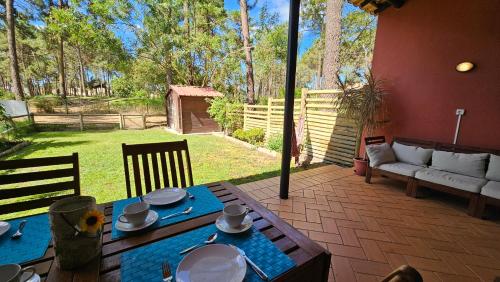 a patio with a table and a couch in a yard at Apartamento Herdade Aroeira, Praia, Golfe perto Lisboa in Almada
