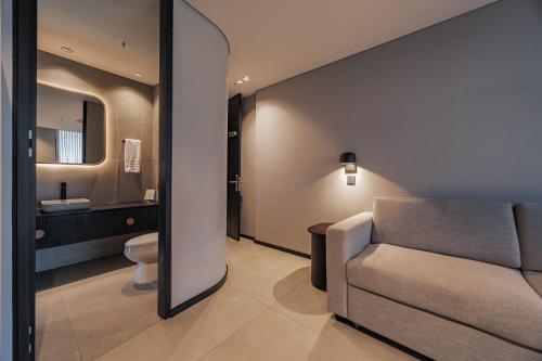a living room with a couch and a bathroom at Seissta Medellín in Medellín