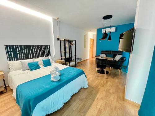 a bedroom with a blue and white bed and a desk at Apartamentos Suites Capitolio in Mérida