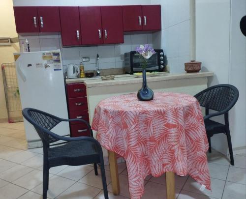 a kitchen with a table with a vase of flowers on it at 80-1 CRISS RESORT-CITY CENTER-NAAMA BAy in Sharm El Sheikh