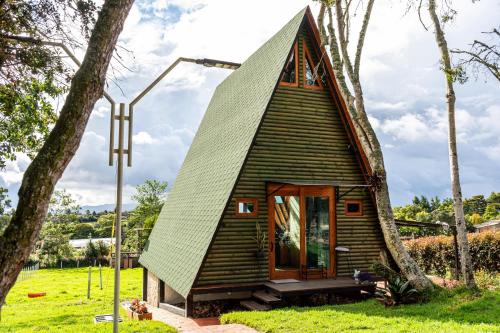 a small tree house with a pitched roof at Cabañas El Edén in Chía