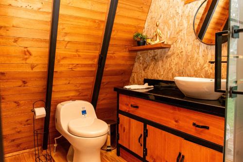 a bathroom with a toilet and a sink at Cabañas El Edén in Chía