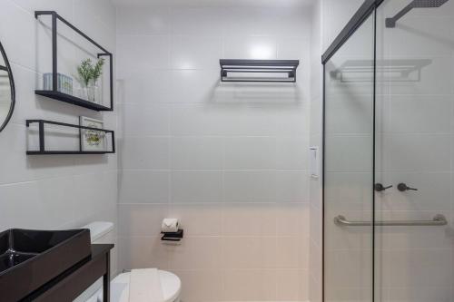 a bathroom with a toilet and a glass shower at Refúgio Moderno no Campo Belo NOVO in Sao Paulo