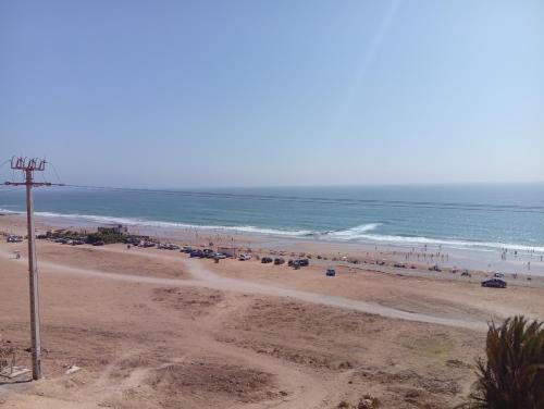 a beach with a lot of people and the ocean at appartement de vacance Aourir2 in Aourir