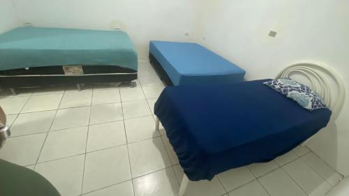 a room with two beds in a room with a fan at Espaço de Iguaba Grande in Iguaba Grande