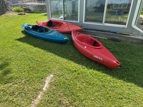 three kayaks sitting on the grass next to a house at Trolleys at Pebble Beach in Livonia