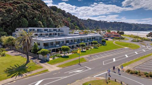 an aerial view of a building with a street and a road at Beachpoint Apartments in Ohope Beach