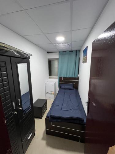a small room with a bed and a mirror at Luxury Rooms in Sharjah
