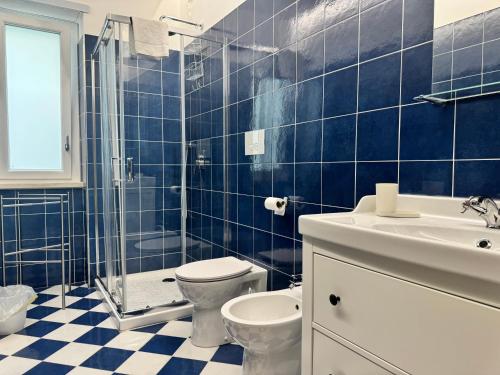 a blue tiled bathroom with a toilet and a sink at Sapore di Mare Riviera in Gaeta