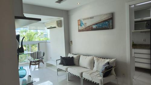 a living room with a couch and a table at Bora Bora Barra Apartments in Rio de Janeiro