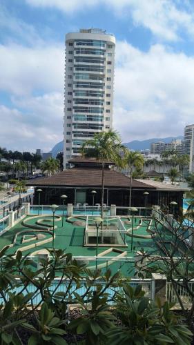 a large building with a tennis court in front of it at Bora Bora Barra Apartments in Rio de Janeiro