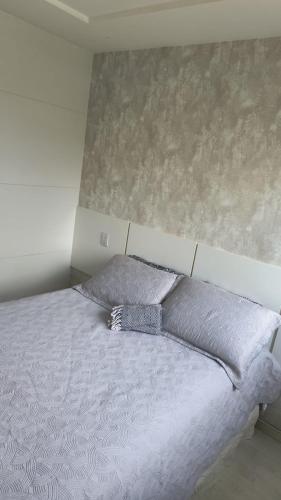 a bed with two pillows on it in a bedroom at Bora Bora Barra Apartments in Rio de Janeiro