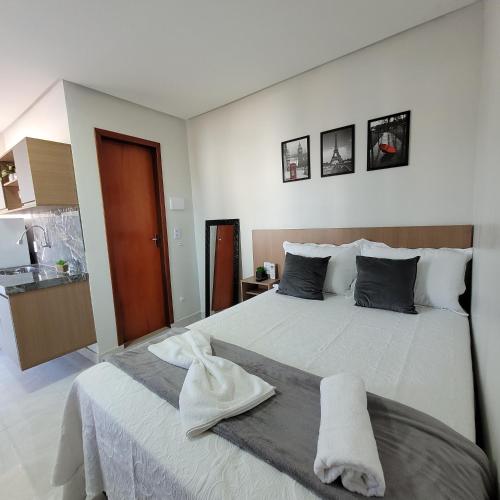 a bedroom with a white bed with a towel on it at Pousada Loft Marabá in Marabá