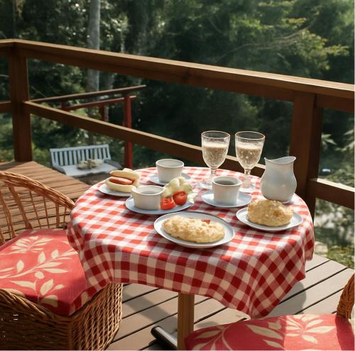a table with plates of food and glasses of wine at Propriedade inteira e Kombi-home em meio à mata in Rancho Queimado