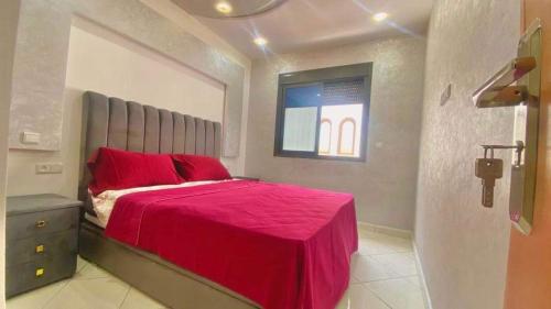 a bedroom with a red bed and a window at Beachfront First floor mekad in Oued Laou