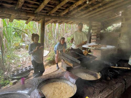 a group of three men standing around a grill at Cascadia in Cocorná