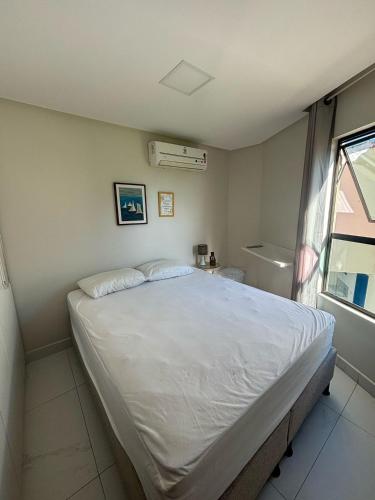 a bedroom with a large white bed and a window at Prive Beira Mar Tamandare in Tamandaré