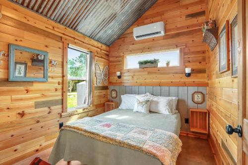 a bedroom with a bed in a wooden cabin at RusTx Ranch Unit 7- Music in Wimberley