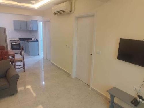 un salon avec un canapé et une télévision sur un mur dans l'établissement 68-5 2 BED ROOM -CRISS RESORT-NAAMA BAY -CITY CeNTER, à Charm el-Cheikh