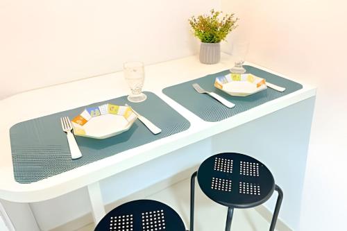 a white table with plates and utensils on it at ASA | Loft | Funcional e Charmoso | Centro Itajaí in Itajaí