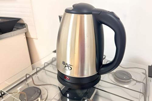 a black and silver tea kettle on a stove at ASA | Loft | Funcional e Charmoso | Centro Itajaí in Itajaí