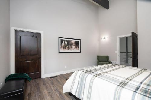 a white bedroom with a bed and a chair at Mariposa Grove Creekside Retreat in Fish Camp