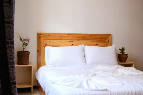 a white bed with white sheets and pillows at Surfer's Heimat Hostel in Tamraght Ouzdar