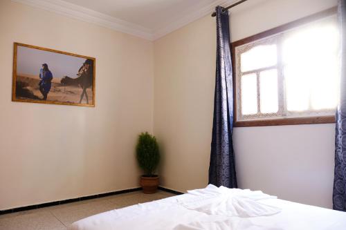 a bedroom with a bed and a window at Surfer's Heimat Hostel in Tamraght Ouzdar