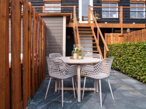 a table and chairs on a patio with a wooden fence at De Vale in Hattemerbroek