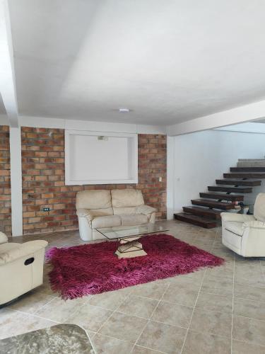 a living room with a couch and a red rug at Extraordinaria Casa con Piscina in Mérida