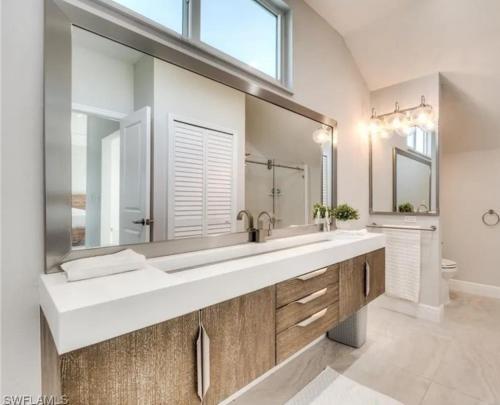 a bathroom with a sink and a large mirror at Luxury Home with Deeded Private Beach Access Sanibel Island - 28 Day Stay Minumum in Sanibel